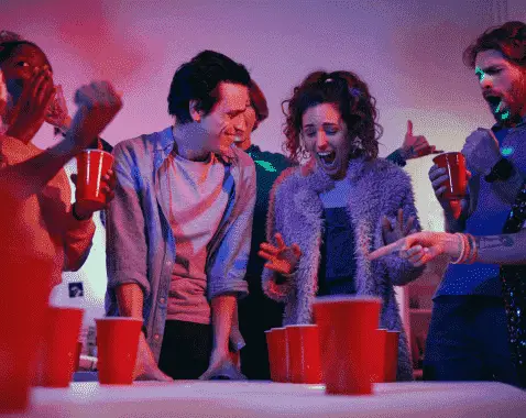 Young people enjoying a social event by playing chandelier drinking game